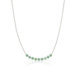 A Birthstone Arc Layering Necklace – White Gold in Emerald – May on a white background.