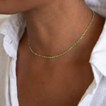 A close-up of a neck wearing a Confetti Necklace - Green. 