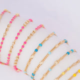 Several Confetti Necklaces in pink, blue and yellow on a white background. 