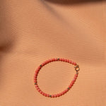 An Endless Summer Bracelet - Mykonos on a light orange fabric background. 
