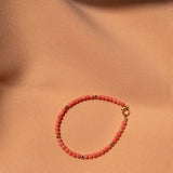 An Endless Summer Bracelet - Mykonos on a light orange fabric background. 
