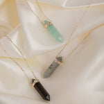 Three Retreat Necklaces - Protection, Courage and In Flow on a cream silk background. 