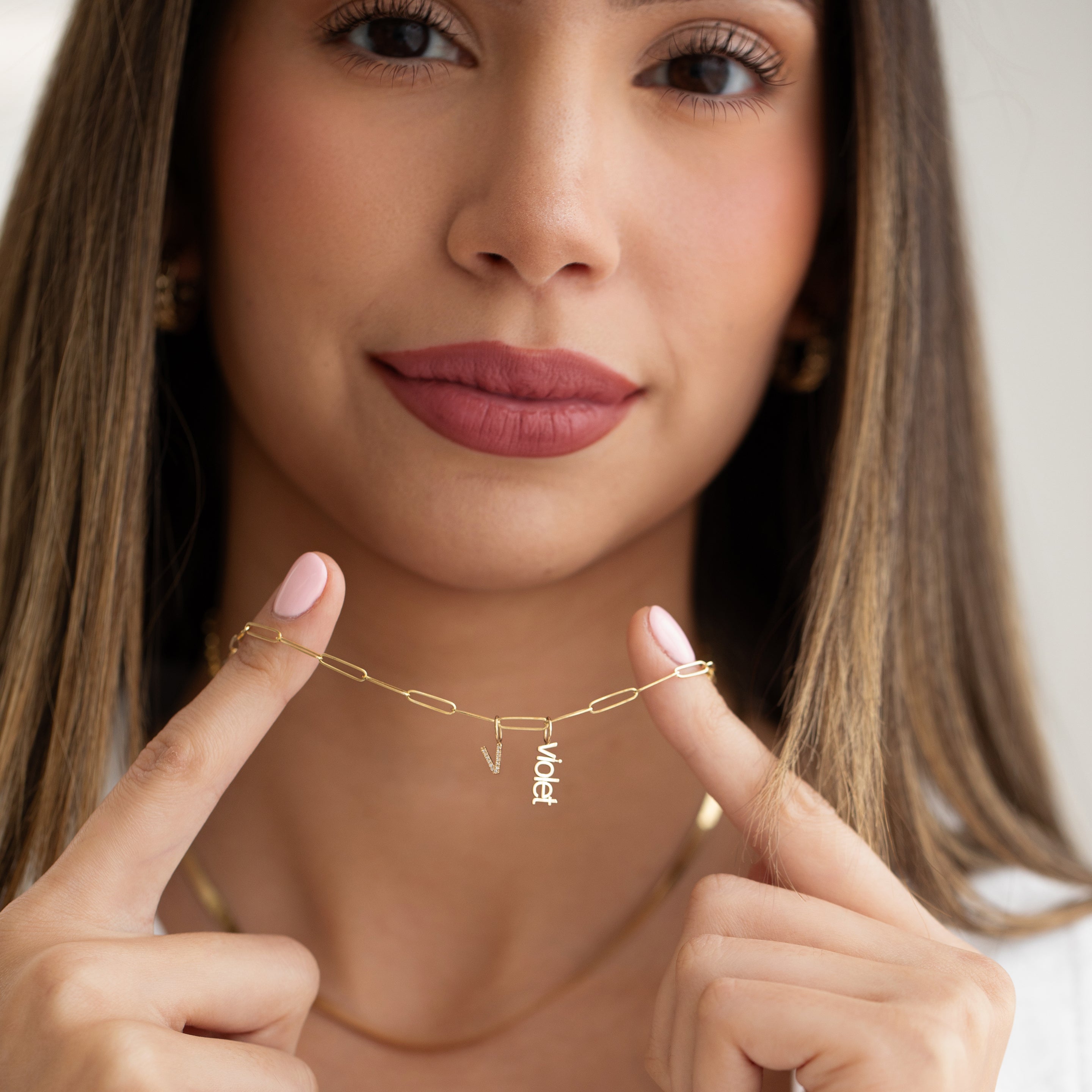 small letter charms nameplate on a gold paperclip chain