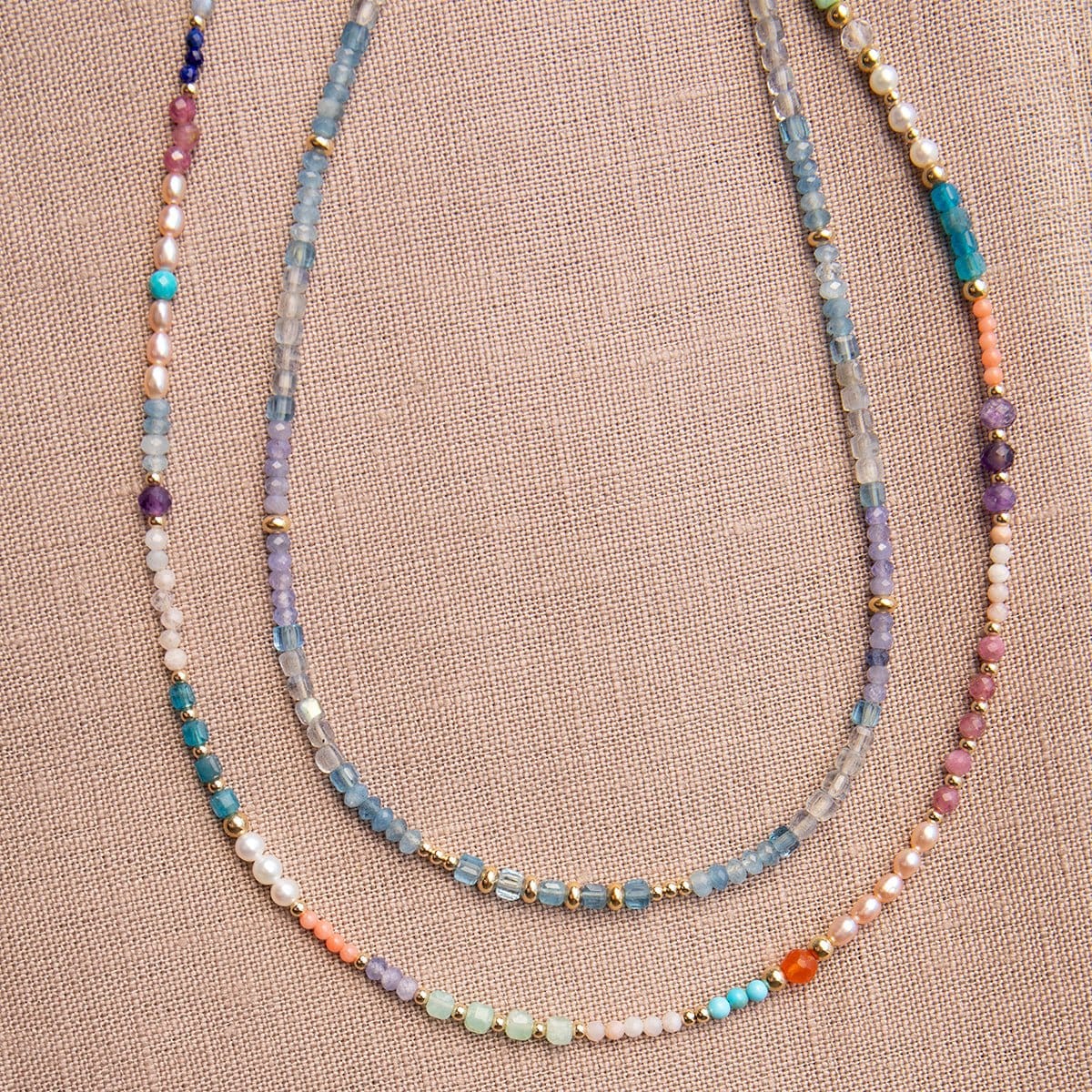 Endless Summer Necklaces - Capri and Blue Lagoon against a neutral fabric background. 