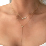 small letter lowercase nameplate necklace 'george' in gold layered with a gold lariat necklace with circle charm center