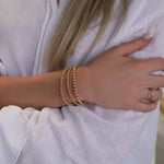 A woman's arm wearing the Statement Bubble Bracelet Set with a white linen shirt.