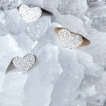Three Love on the Rocks Rings (two white gold and one yellow gold) laid on top of ice. 