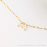 An Element Long Link Chain with three Petite Nameplate Pendants, 'lara', 'd' and 'livia', all in yellow gold on a white background. 