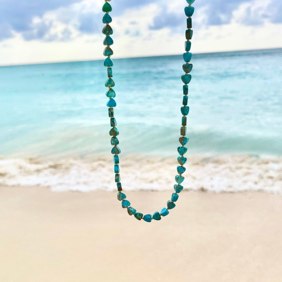 An Endless Summer Necklace - Sea + Sky against a beach background. 