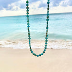 An Endless Summer Necklace - Sea + Sky against a beach background. 