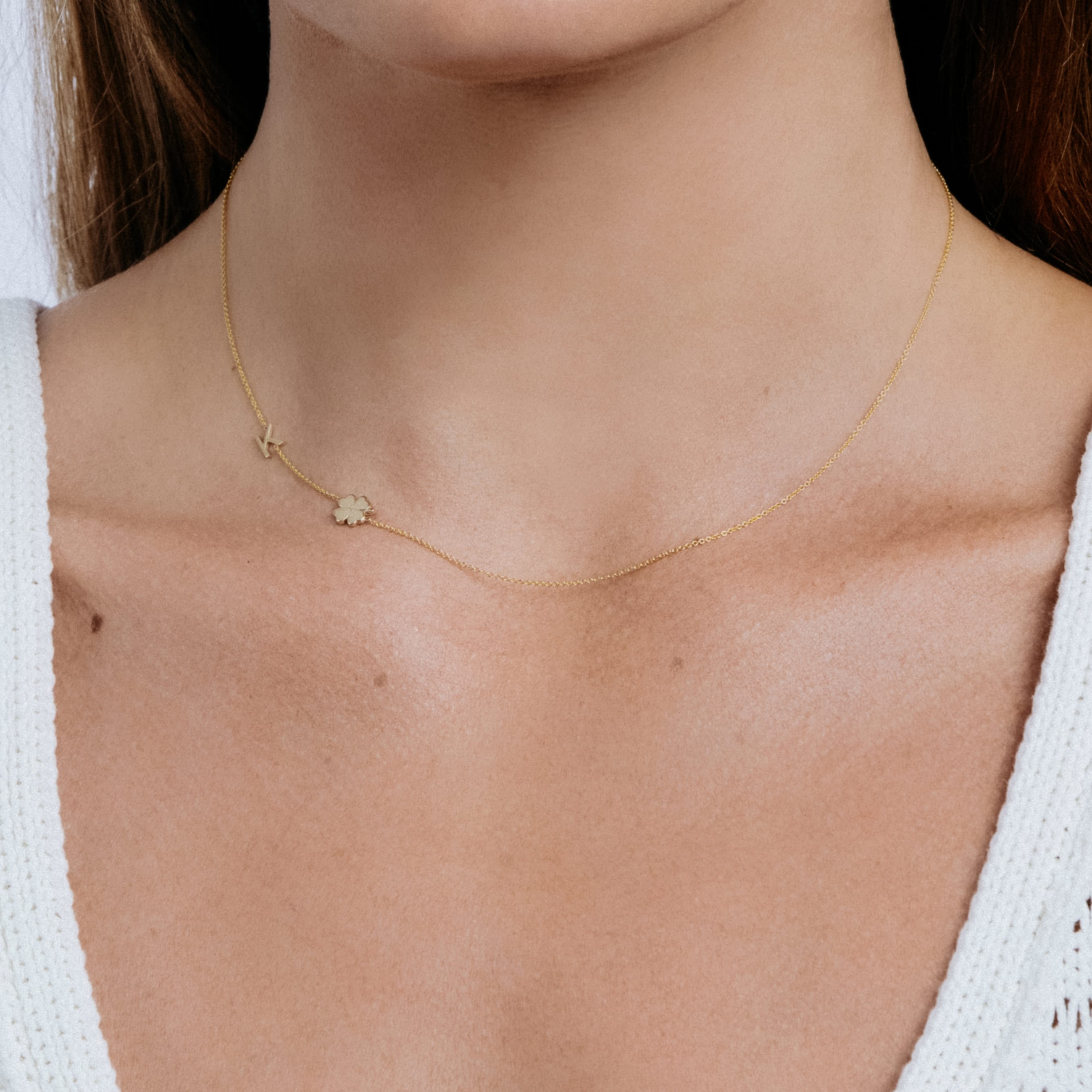 Gold necklace with a small pendant on a person's neck
