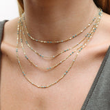 Close-up of a neck wearing several Confetti Necklaces - Blue. 