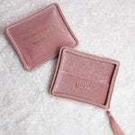 Two pink velvet jewellery boxes with a Pavé Madre Necklace on a textured off-white background. 