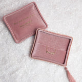 Two pink velvet jewellery boxes with a Pavé Madre Necklace on a textured off-white background. 
