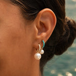 Model wearing the Maya Brenner Mini Pearl Earring Charm on a Turquoise Huggie and the Maxi Pearl Earring Charm on a Pavé Huggie Earring.