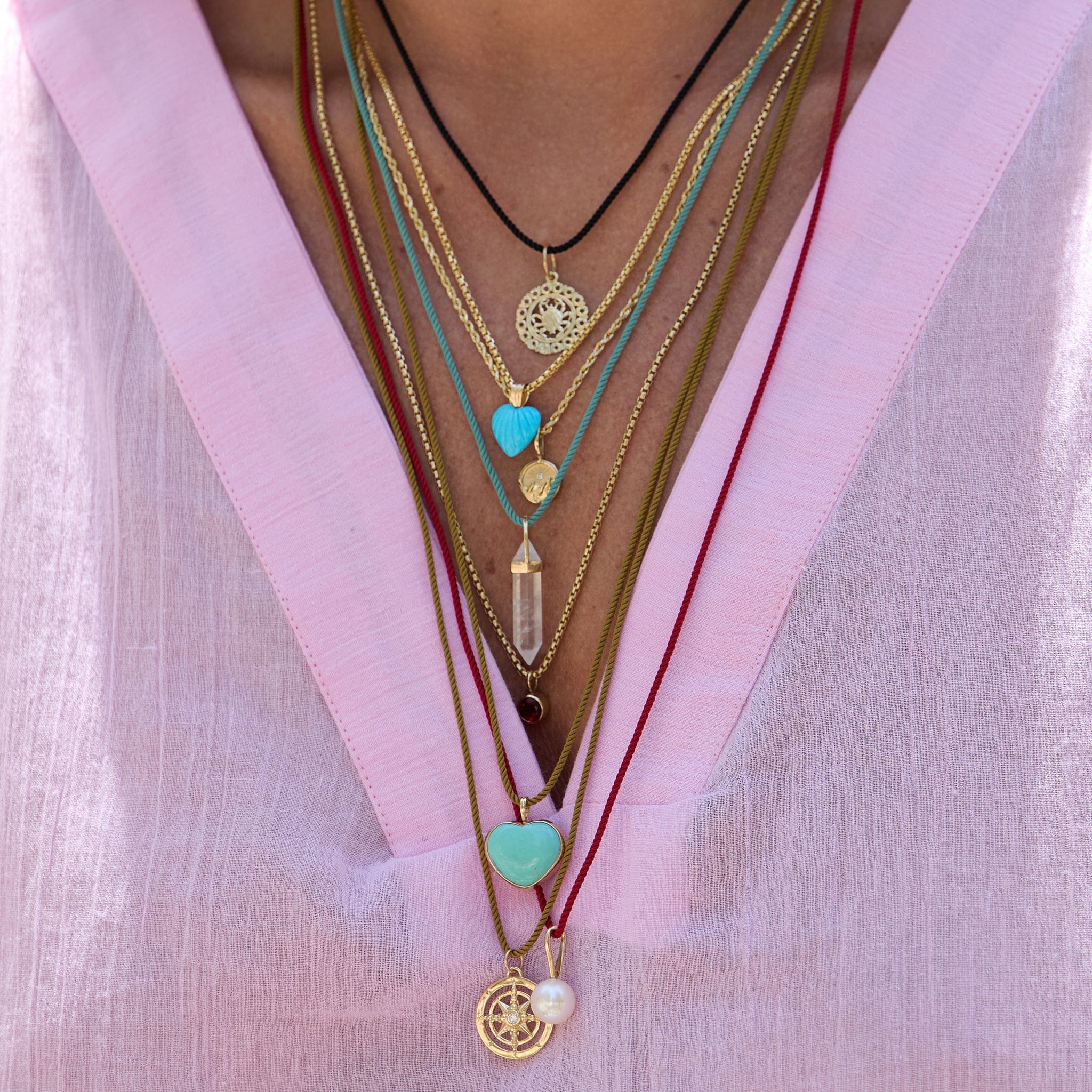Color Cord Necklaces with multiple pendants on model wearing a pink shirt.