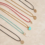 Set of necklaces with various Color Cored Necklaces with pendants on a textured surface