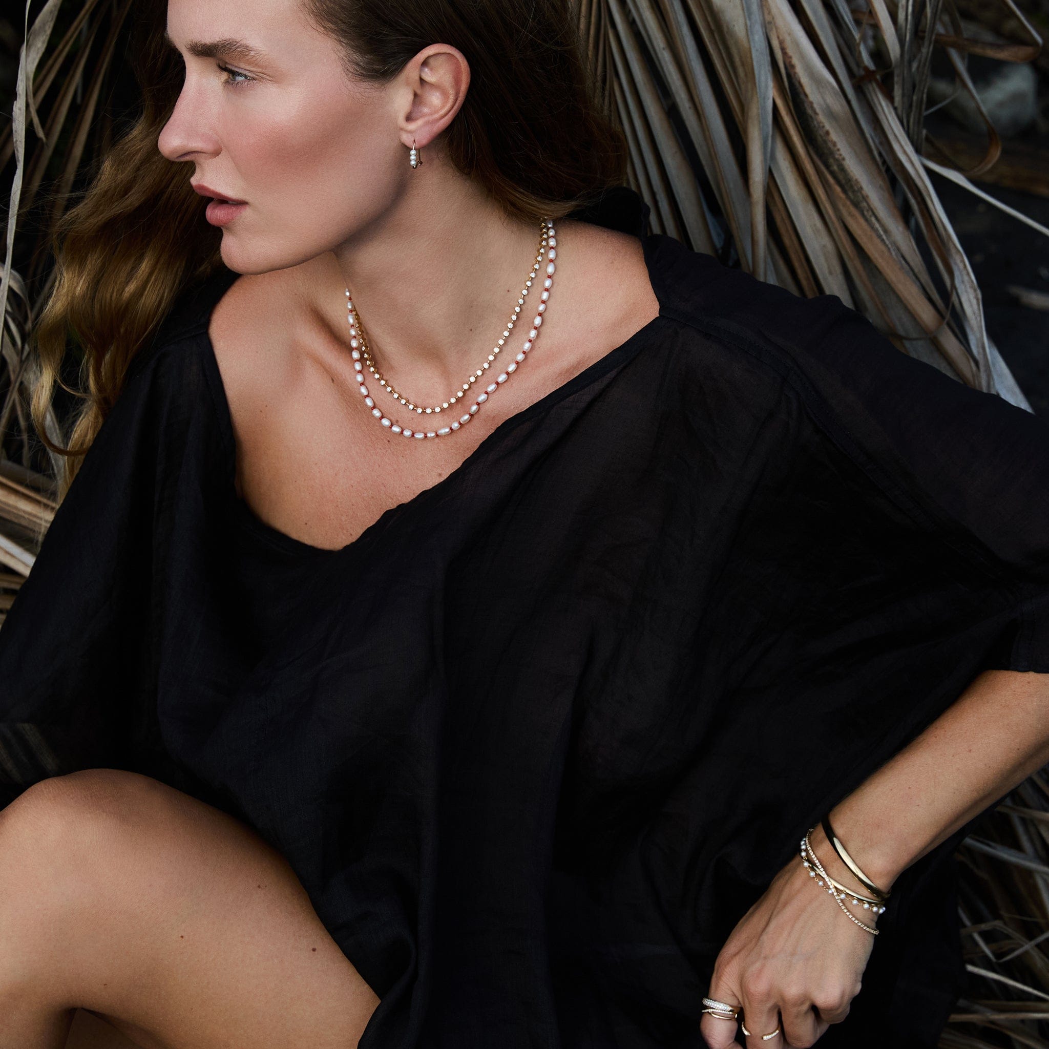 Model wearing Maya Brenner Cabana Pearl Necklace layered with the Ultimate Diamond Necklace, styled with gold rings, pearl bracelet, and gold cuff
