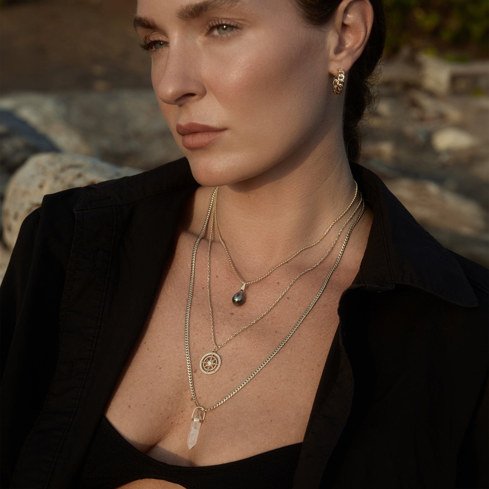 Model wearing the Nautical Rope Chain with the Find Your Way Pendant in a layered gold necklace stack.