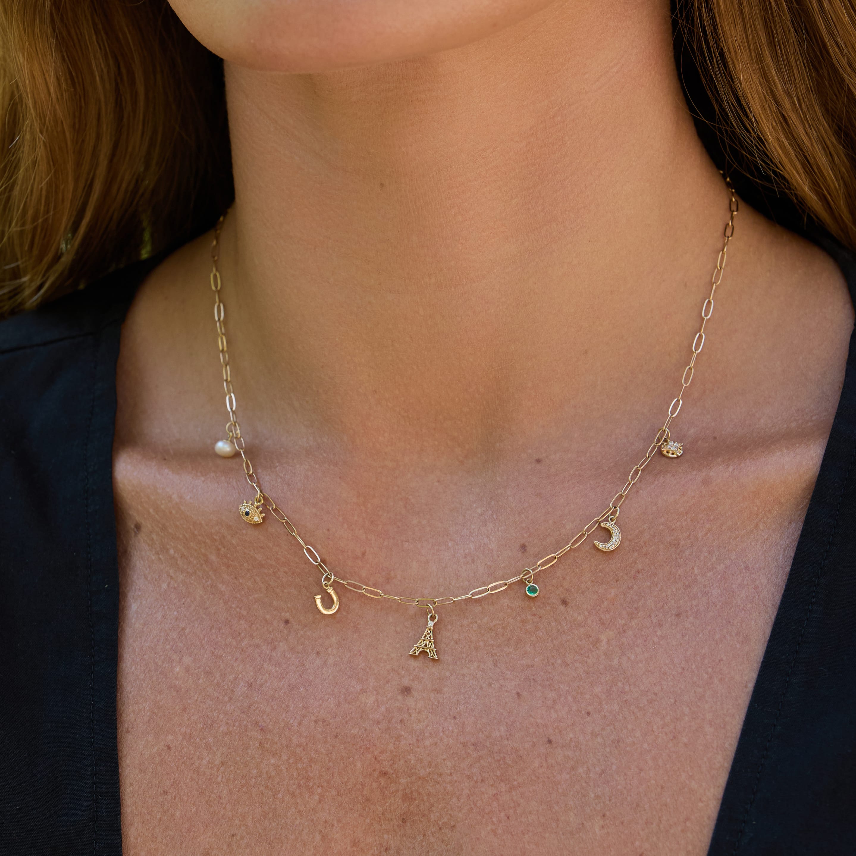 woman wearing charm necklace with black shirt