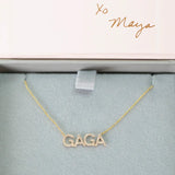 A Pavé GAGA Necklace in yellow gold with a cable chain in a Maya Brenner light grey and pink jewellery box. 