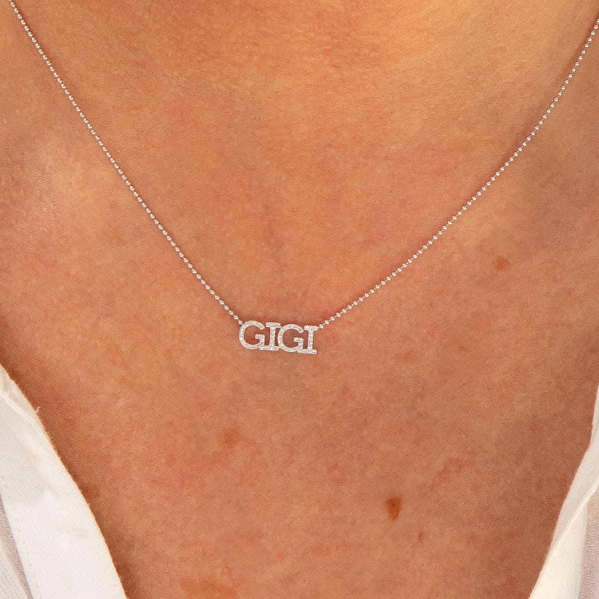 Close-up of a décolletage wearing a Pavé GIGI Necklace with a bead chain. 