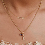Gold necklace with 'margot' and 'mom' pendant on a person's neck