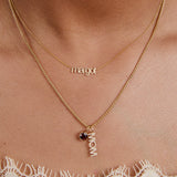 Gold necklace with 'margot' and 'mom' pendant on a person's neck