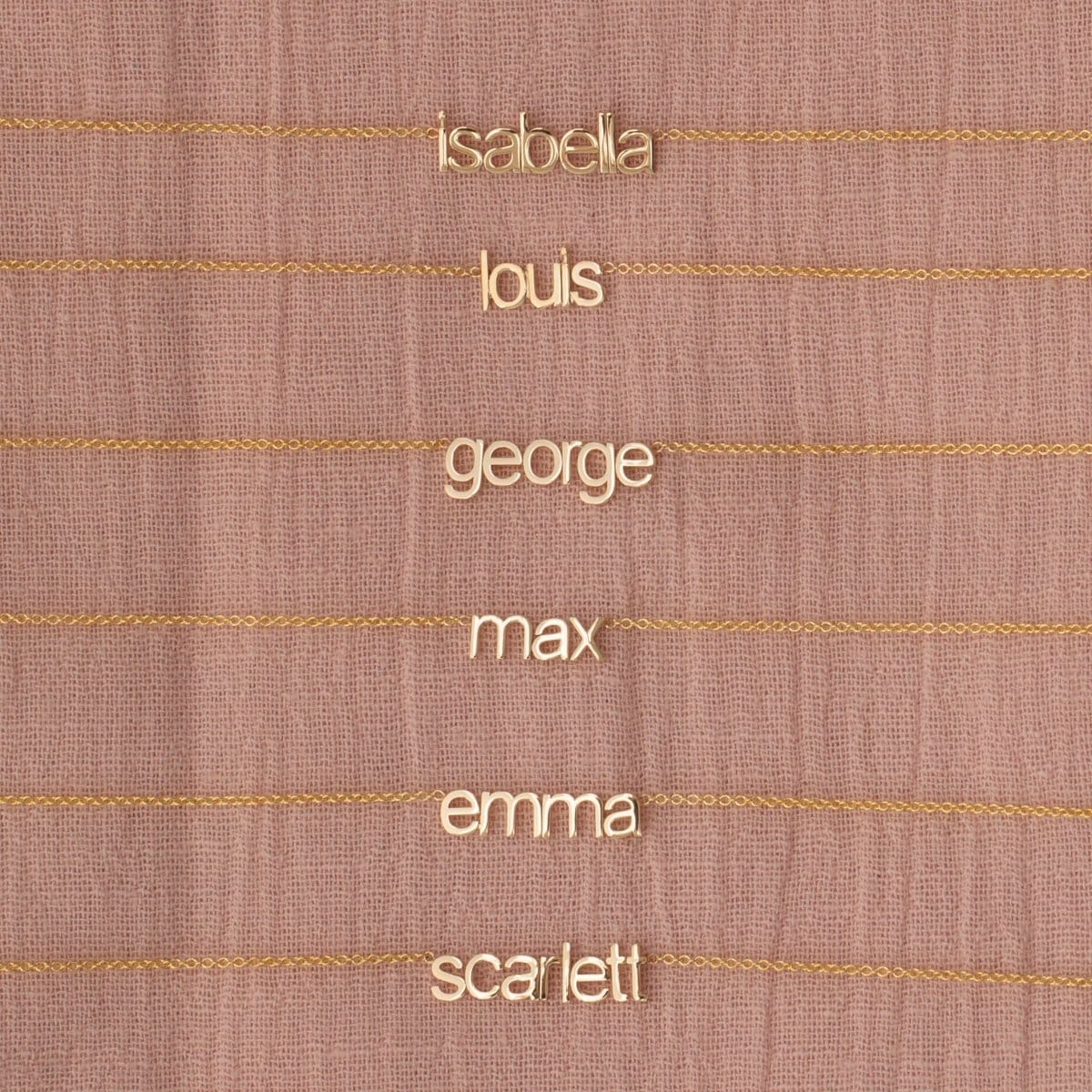 small nameplate necklaces on pink background