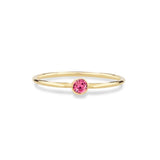 pink tourmaline birthstone on gold ring on white background