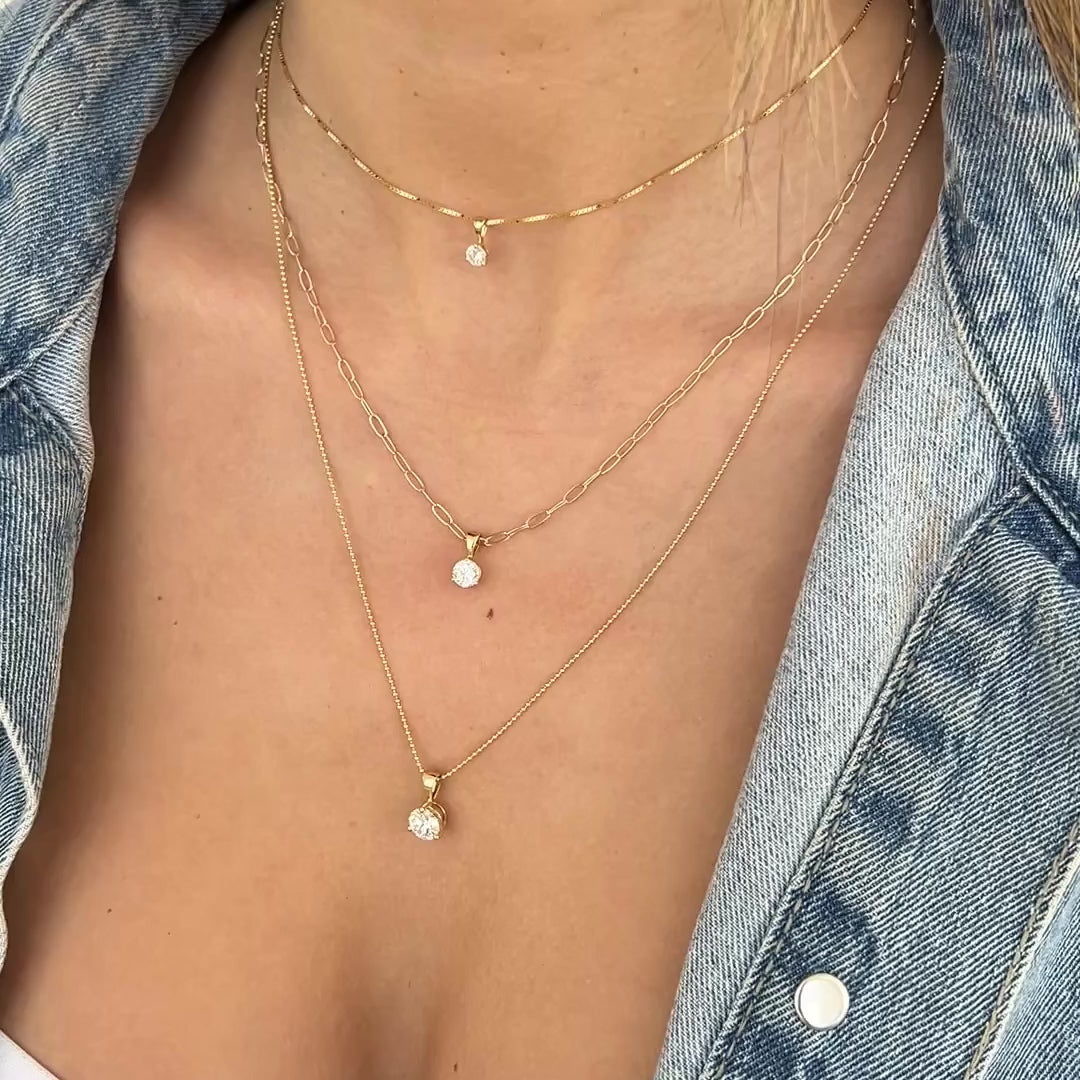 A video of a decellotage wearing a Duchess Diamond Pendant on The Slide Chain, Princess Diamond Pendant on a Short Element Link Chain and a Queen Diamond Pendant on a Classic Bead Chain with a denim jacket. 