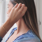 A video of a woman wearing a Starstruck Diamond Lariat Necklace and Bracelet and an Off the Cuff Bracelet, all in yellow gold, styled in a blue dress. 