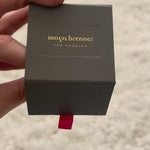 A jewellery box with The Evermore Ring inside against an off-white fluffy background. 