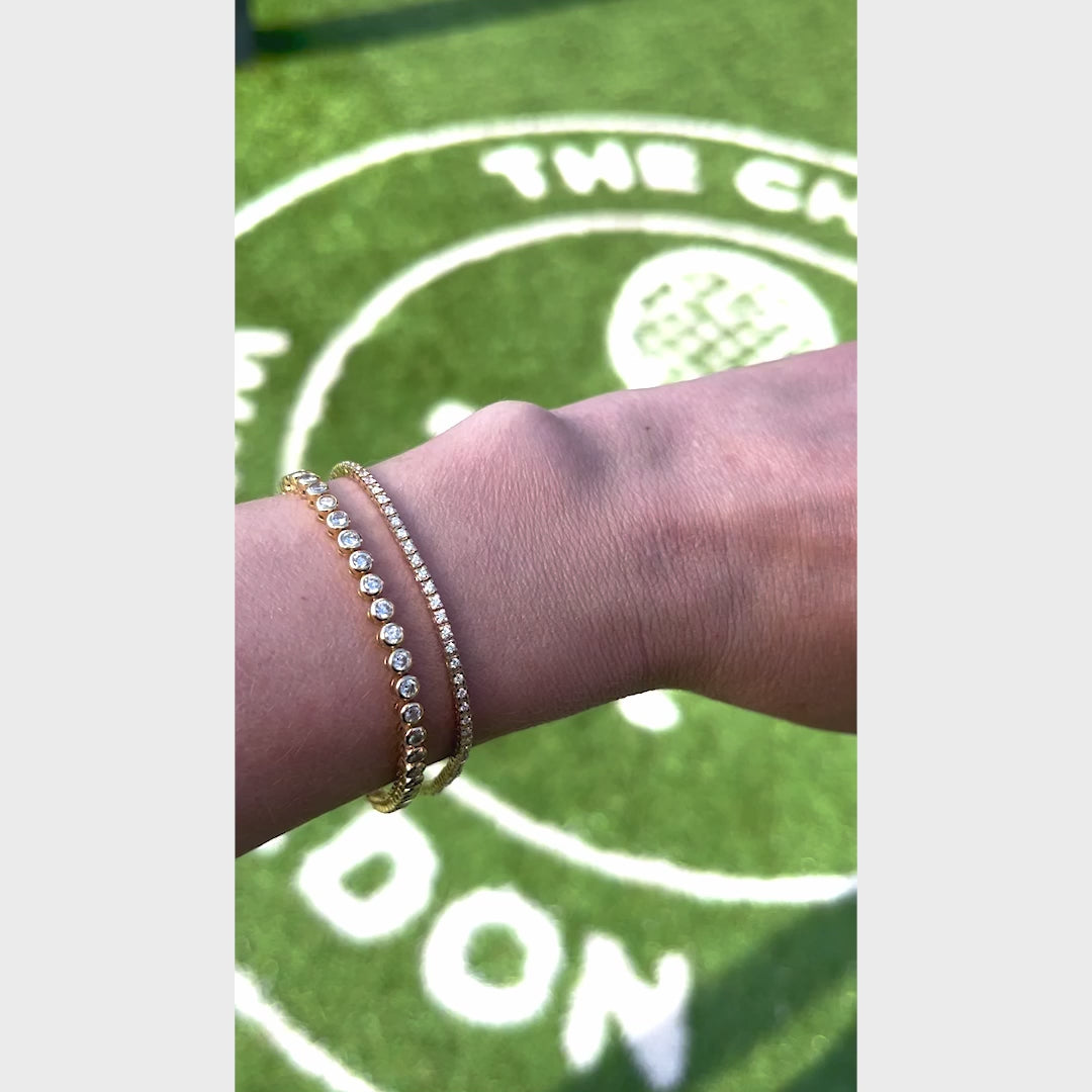 A video of a Love Set Match Bracelet and Down the Line Bracelet against a Wimbledon green grass background. 
