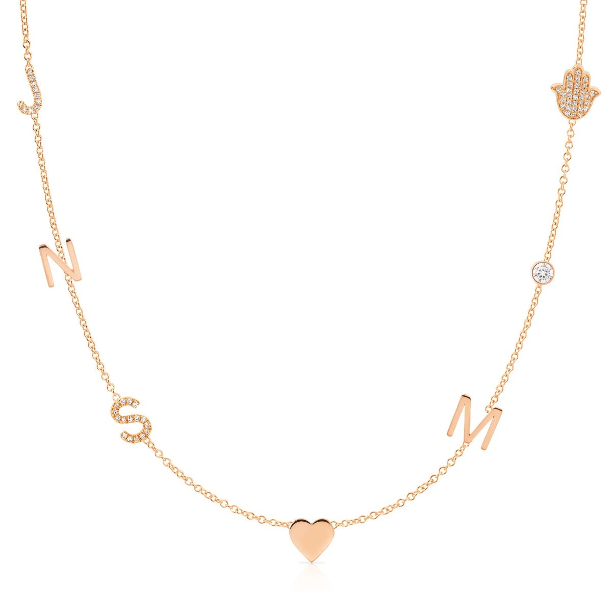 A Custom Gold Necklace in rose gold with seven charms, pavé letters J and S, letters N and M, a heart, a birthstone and a pavé hand, on a white background.