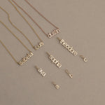 mini letter vertical and horizontal nameplate necklaces in 14k gold. small initial letter pendants.