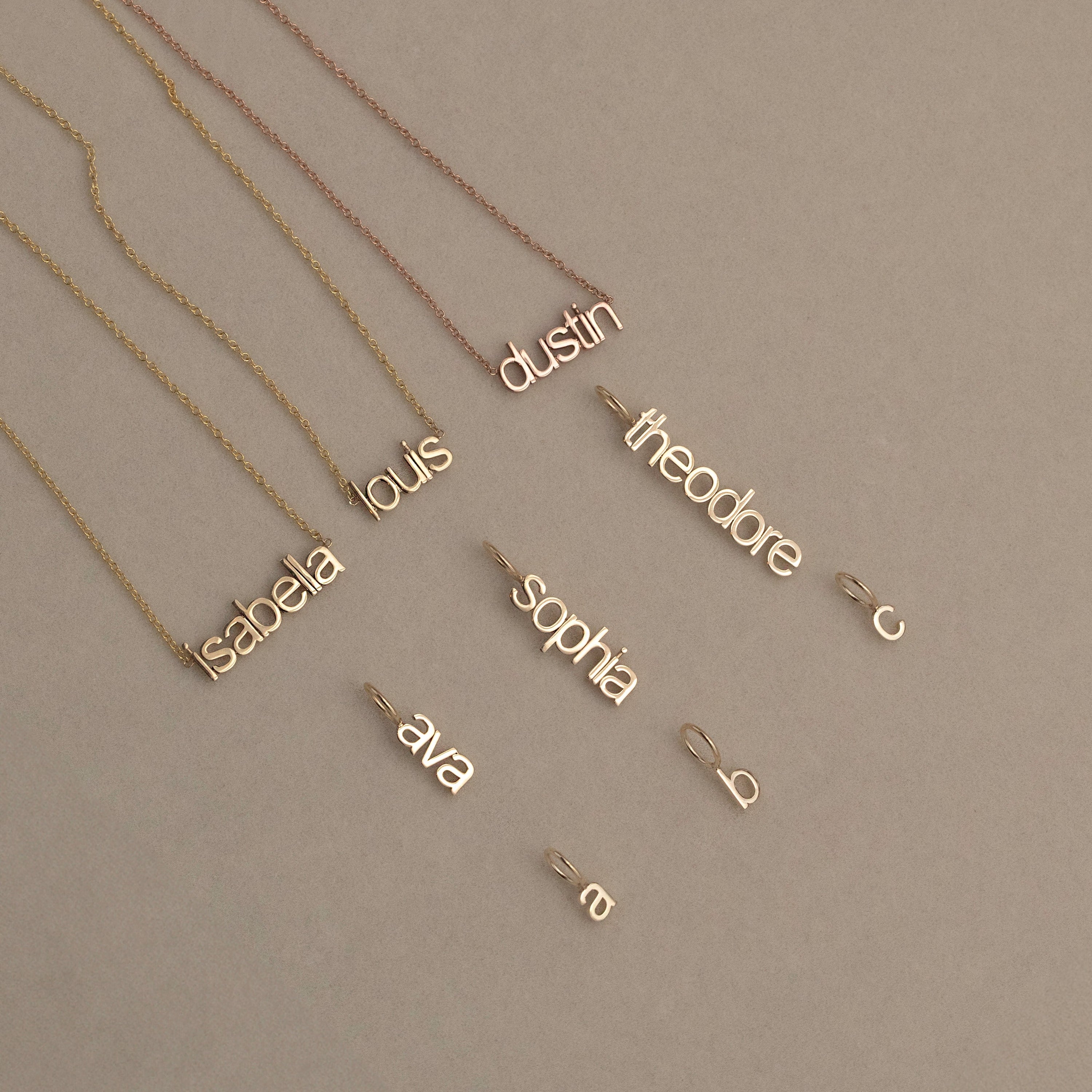 mini letter vertical and horizontal nameplate necklaces in 14k gold. small initial letter pendants.