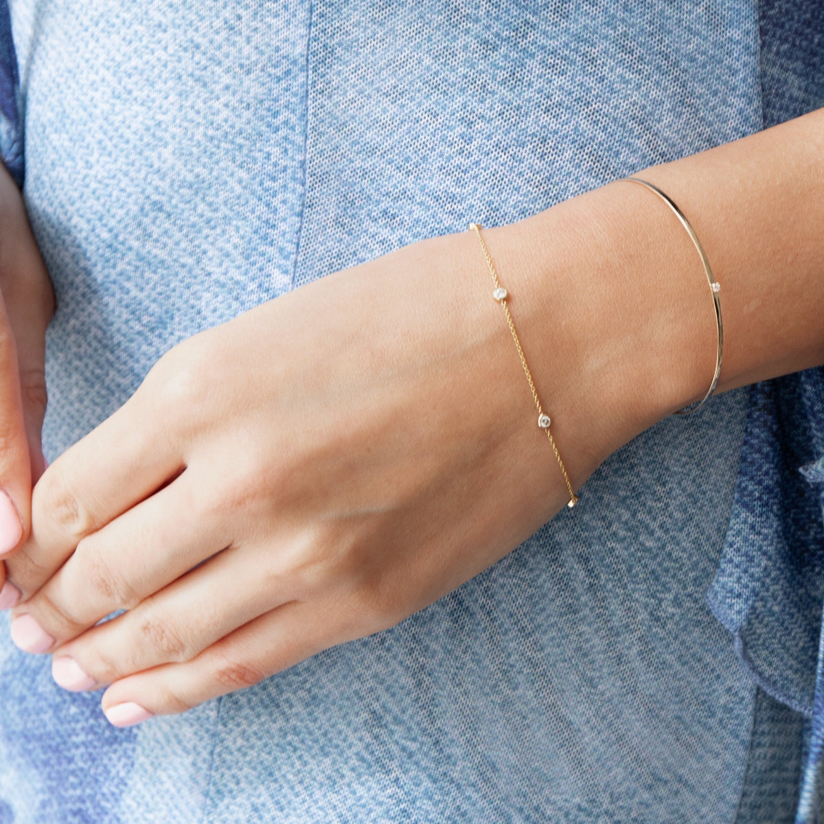 a close up of a woman wearing two diamond bracelets
