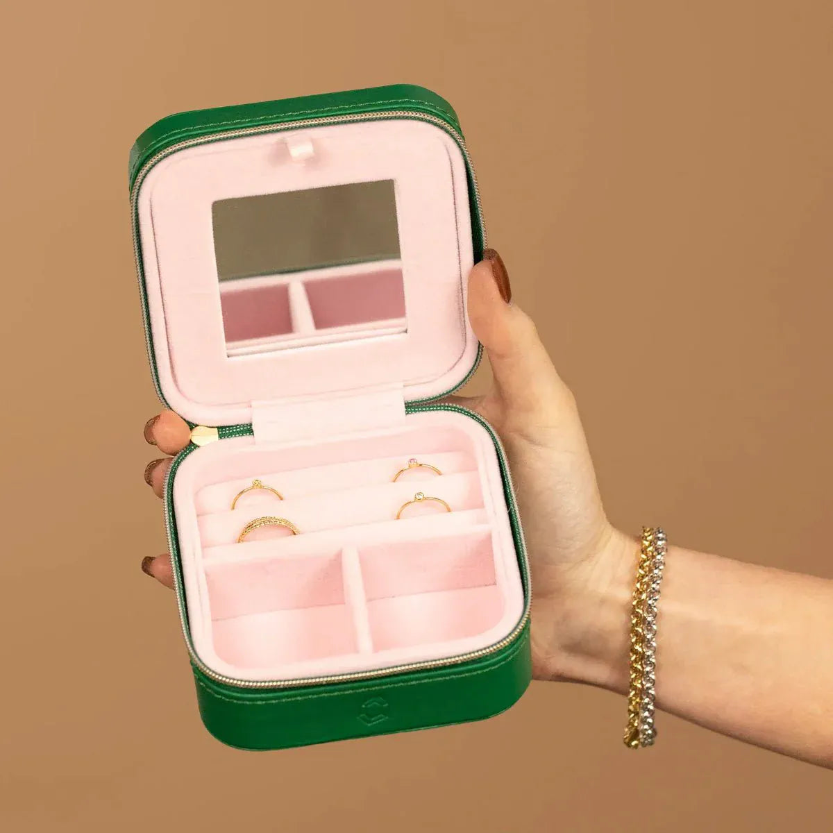 A Travel Jewelry Case - Green/Pink on a light brown background. 