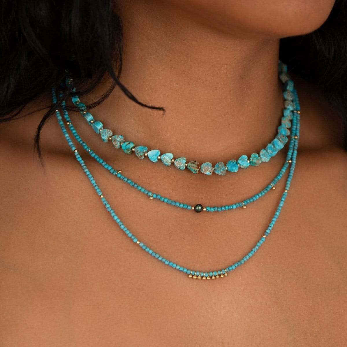 Close-up of a woman's neck wearing Endless Summer Necklaces in Santorini, Turqs + Caicos and Sea + Sky. 