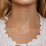 Close-up of a person wearing a gold necklace with star pendants.
