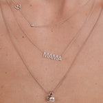 Silver 'MAMA' necklace on a person's neck with a close-up view.