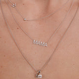 Silver 'MAMA' necklace on a person's neck with a close-up view.