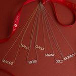 Pavé MADRE, Pavé NANA, Pavé GAGA, Pavé GIGI, MAMA, and MOMMY Necklaces tied to a red ribbon against a red background.