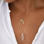 Close-up of a person's neck wearing a yellow gold Classic Bead Chain with three Petite Nameplate Pendants (sophia, joe and theodore) and The Clarity Retreat Necklace.