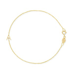 A gold cable chain bracelet with a letter A charm. 