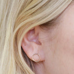 Close-up of a yellow gold Open Eclipse Earring - Small in a blonde woman's ear. 