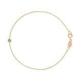 Rose gold bracelet with a small emerald green birthstone charm on a white background.