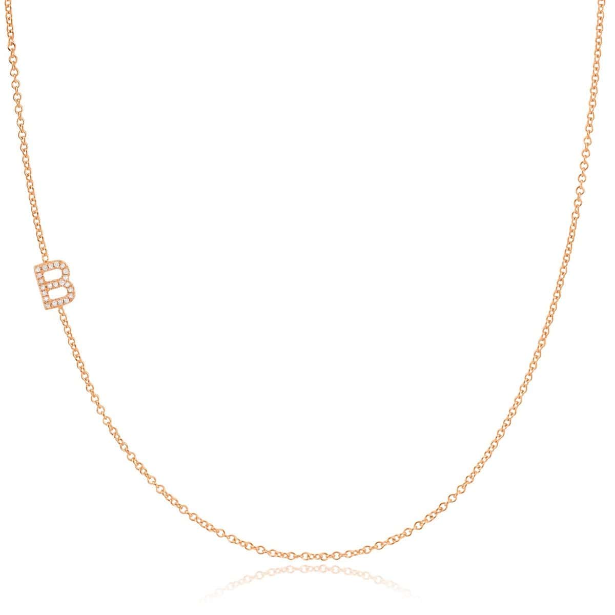 A rose gold necklace with a pave letter B charm on a white background. 