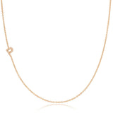 A rose gold necklace with a pave letter P charm on a white background. 